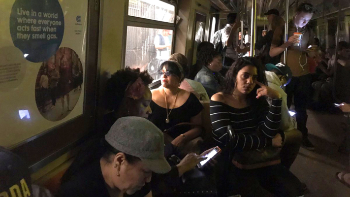 This photo provided by Jackie Faherty from her Twitter page shows subway passengers on an A train with the lights out after it halted just shy of the 125th street stop in New York's Harlem neighborhood, Tuesday, June 27, 2017, in New York. (Jackie Faherty via AP)