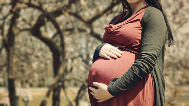 A pregnant woman holding her stomach