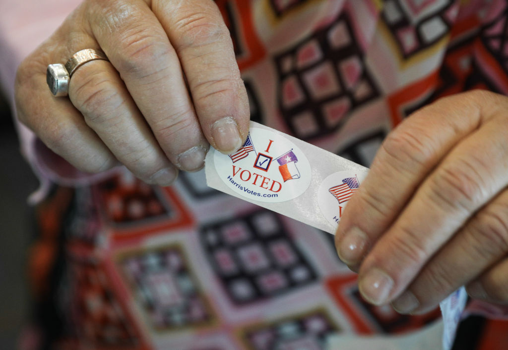 A voter in Texas hands out "I voted" stickers