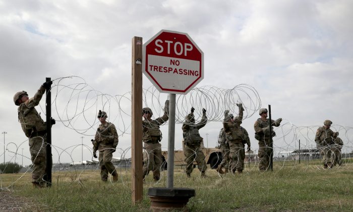 Army soldiers install barbed wire at the U.S.-Mexico border