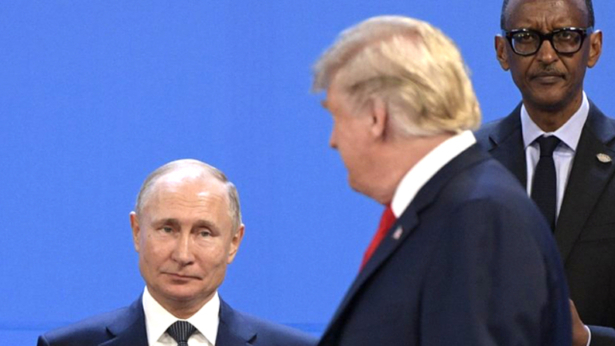 US President Donald Trump (R), looks at Russia's President Vladimir Putin