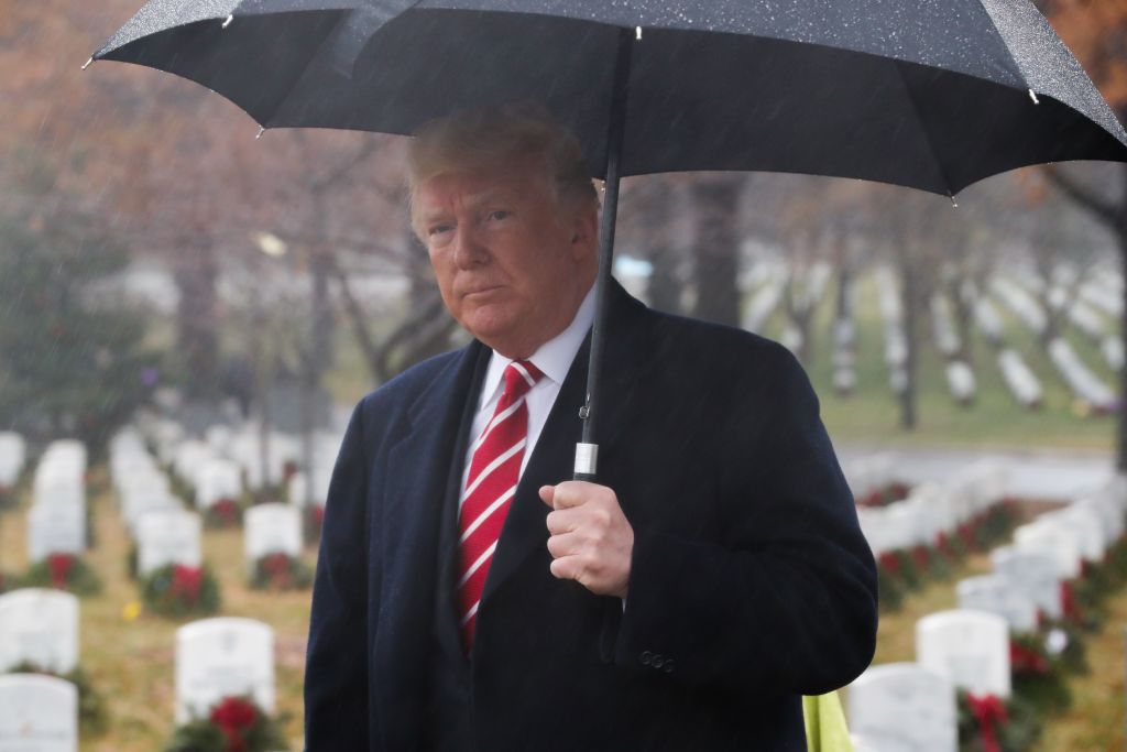President Trump holding black umbrella in rain