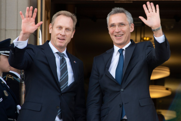 Acting Secretary of Defense Patrick Shanahan (L) waves as NATO Secretary General Jens Stoltenberg
