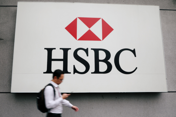 A-man-walks-past-a-logo-of-HSBC