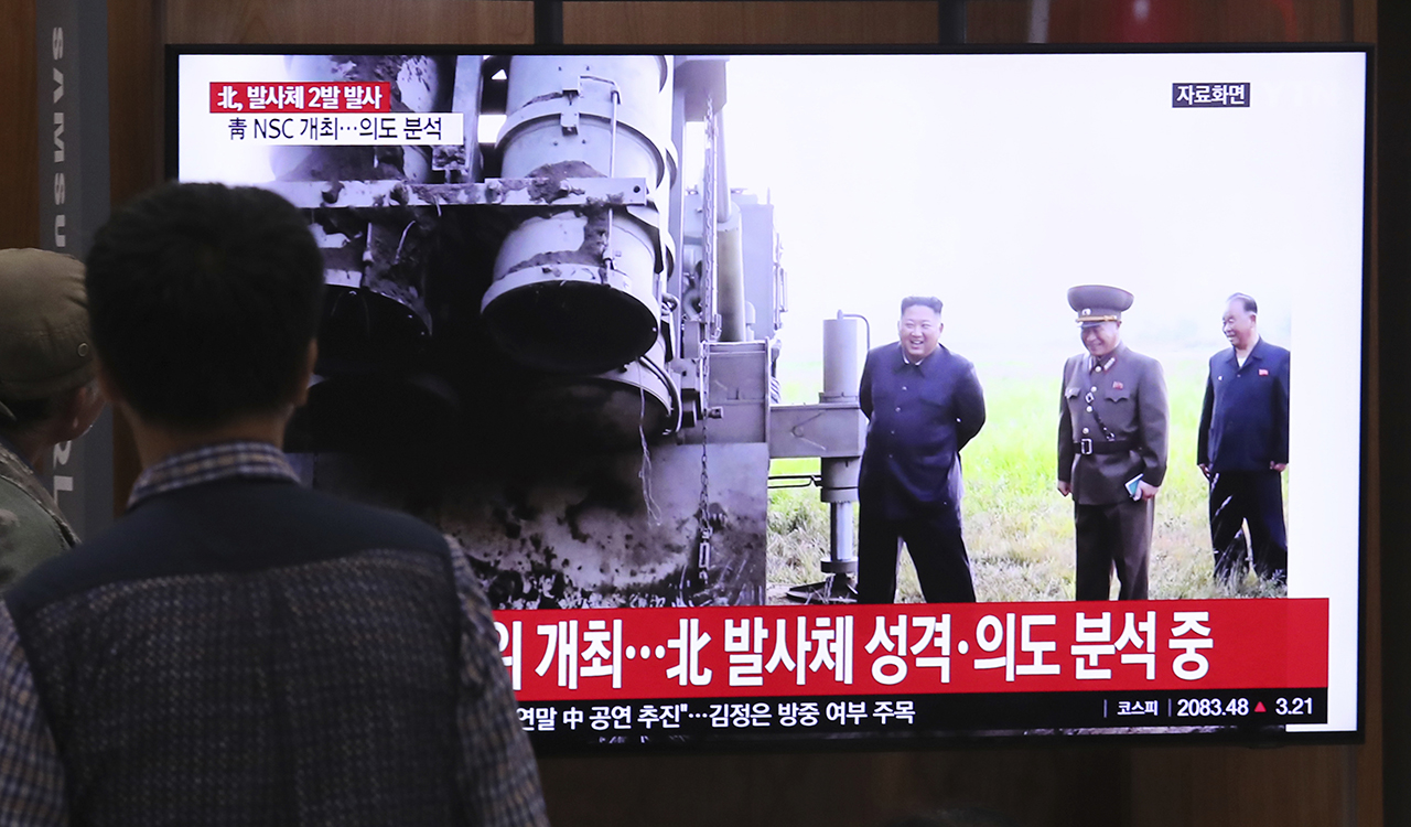People watch a TV showing a file image of North Korean leader Kim Jong Un