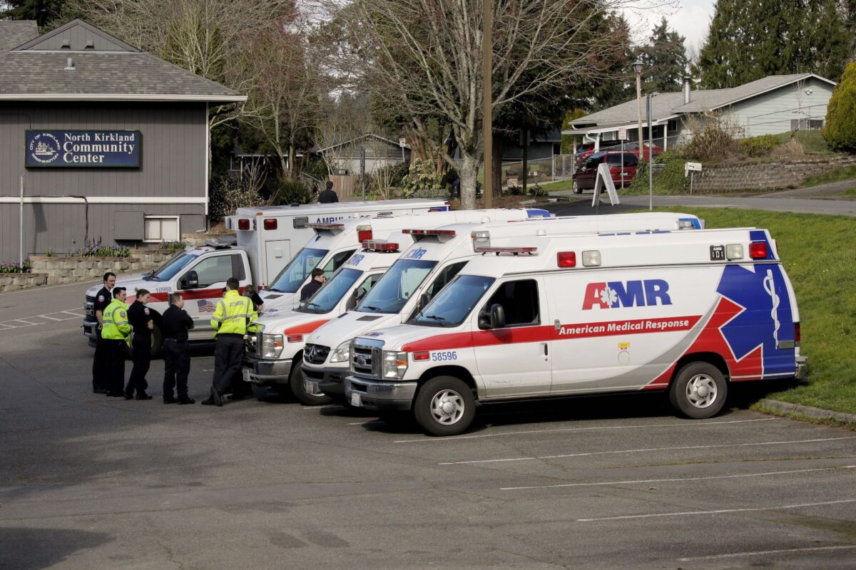Ambulances are seen in a staging area