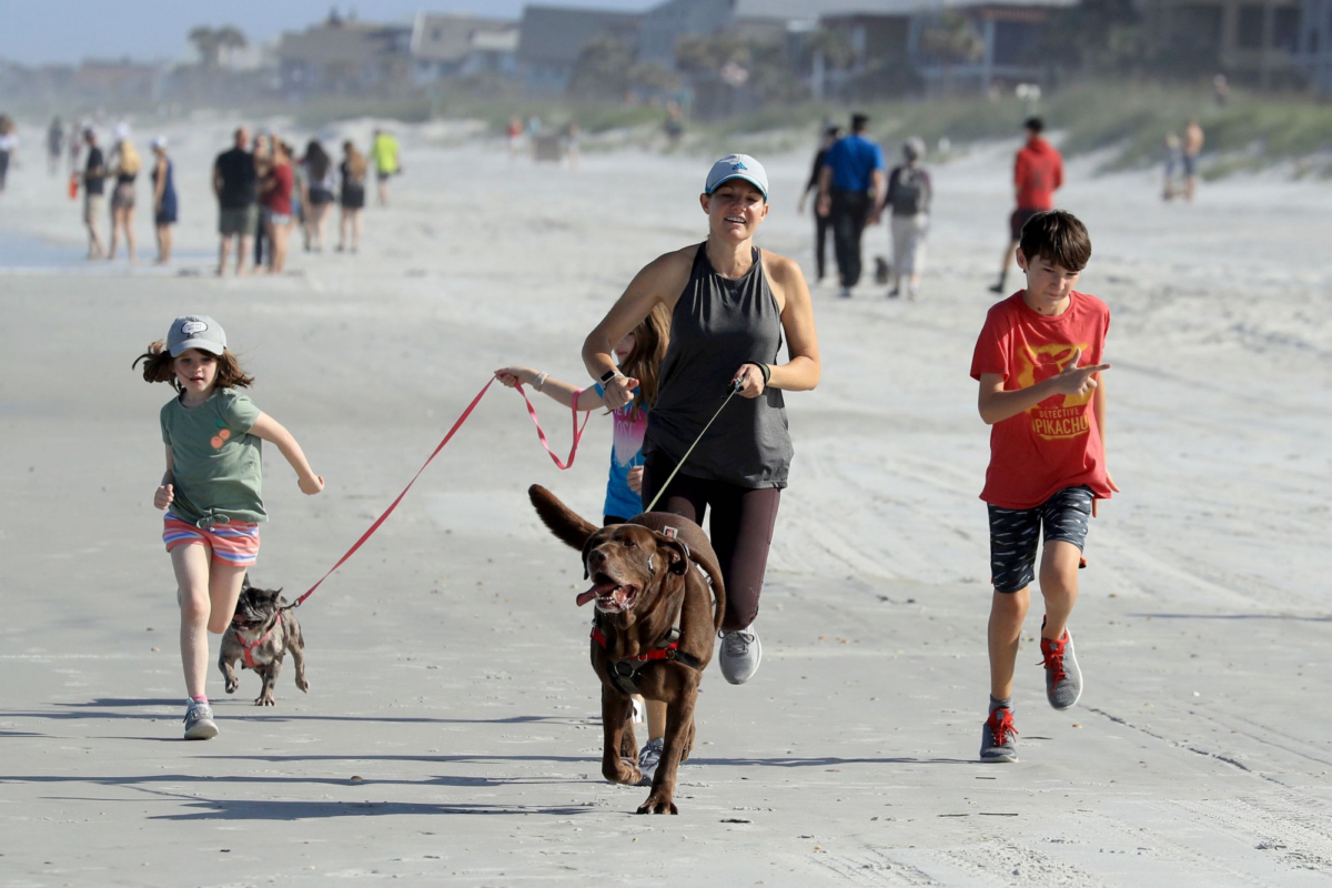 A family runs on the beach in Jacksonville Beach