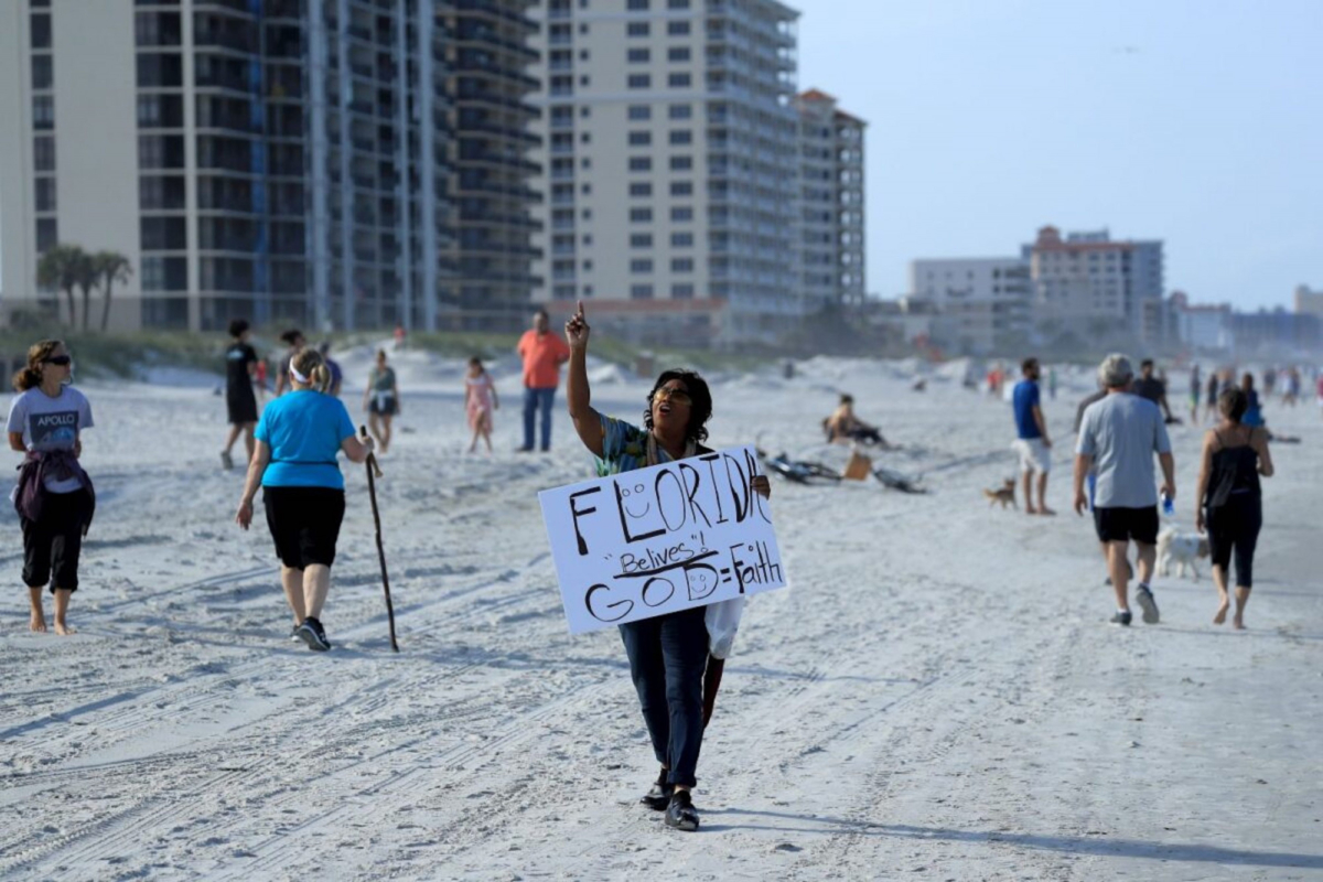 People with sign on Jacksonville Beach