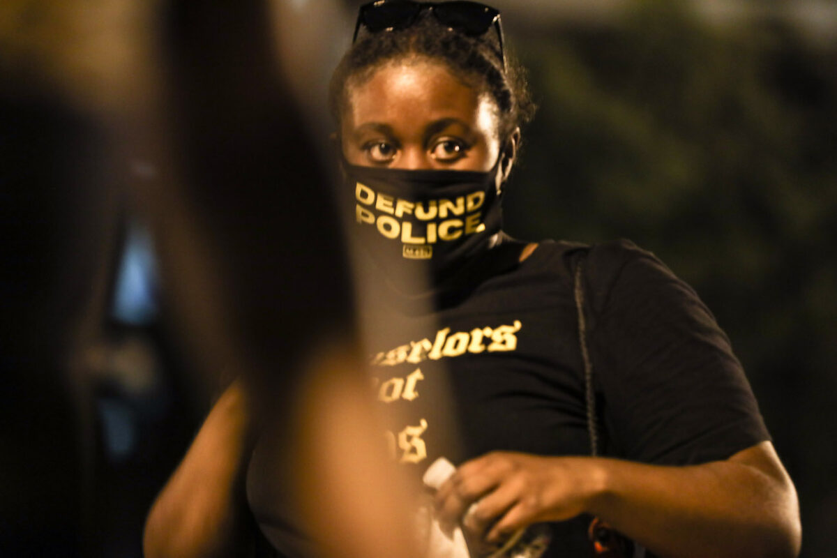 woman with a “Defund Police” face mask