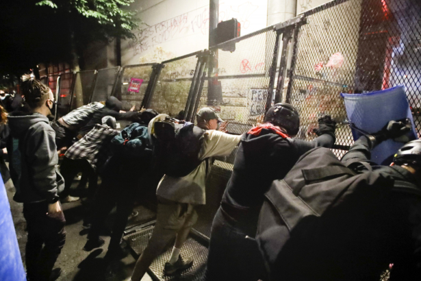 Rioters push fence