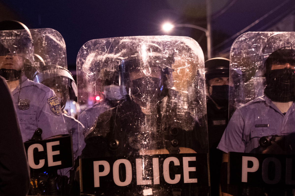 Police in riot gear face protesters