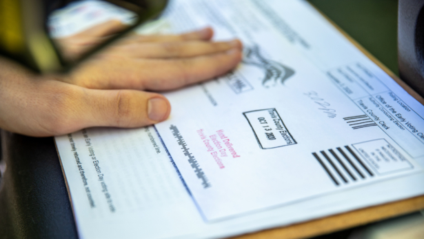 A poll worker stamps a voters