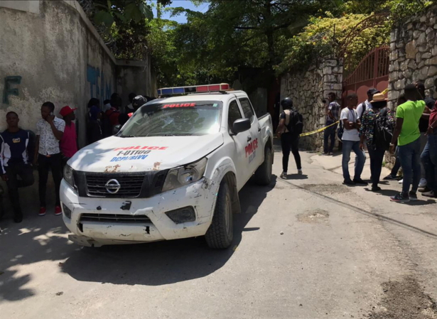 People stand next to a police car near the residence of Haiti's President Jovenel Moise after he was shot dead by unidentified attackers, in Port-au-Prince
