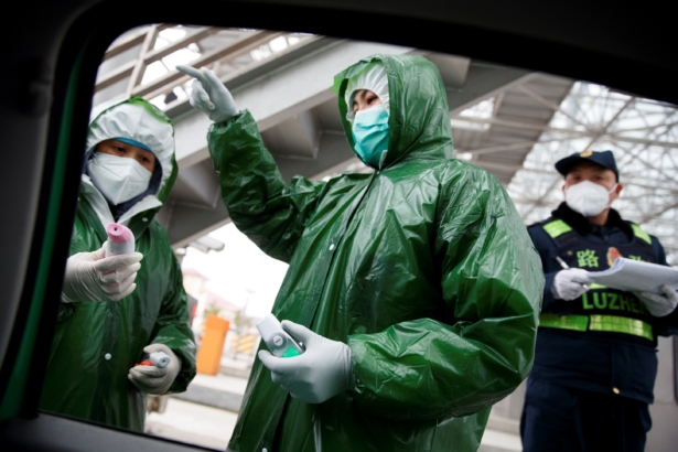 Medical and security workers stand at a checkpoint to screen for the new coronavirus