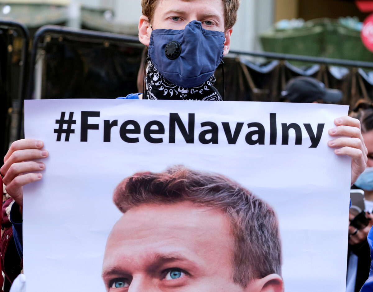 A protester holds a poster of Alexei Navalny