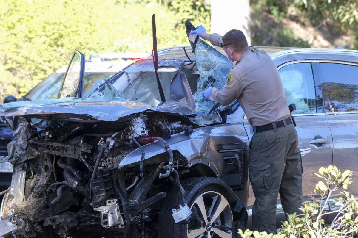 officer looks over a damaged vehicle