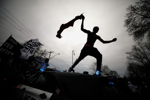 A demonstrator jumps off a police cruiser