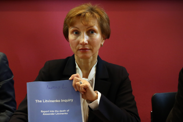 Marina Litvinenko holds a copy of a report at a press conference in her lawyer