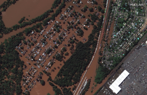 a rail yard and homes submerged in floodwater